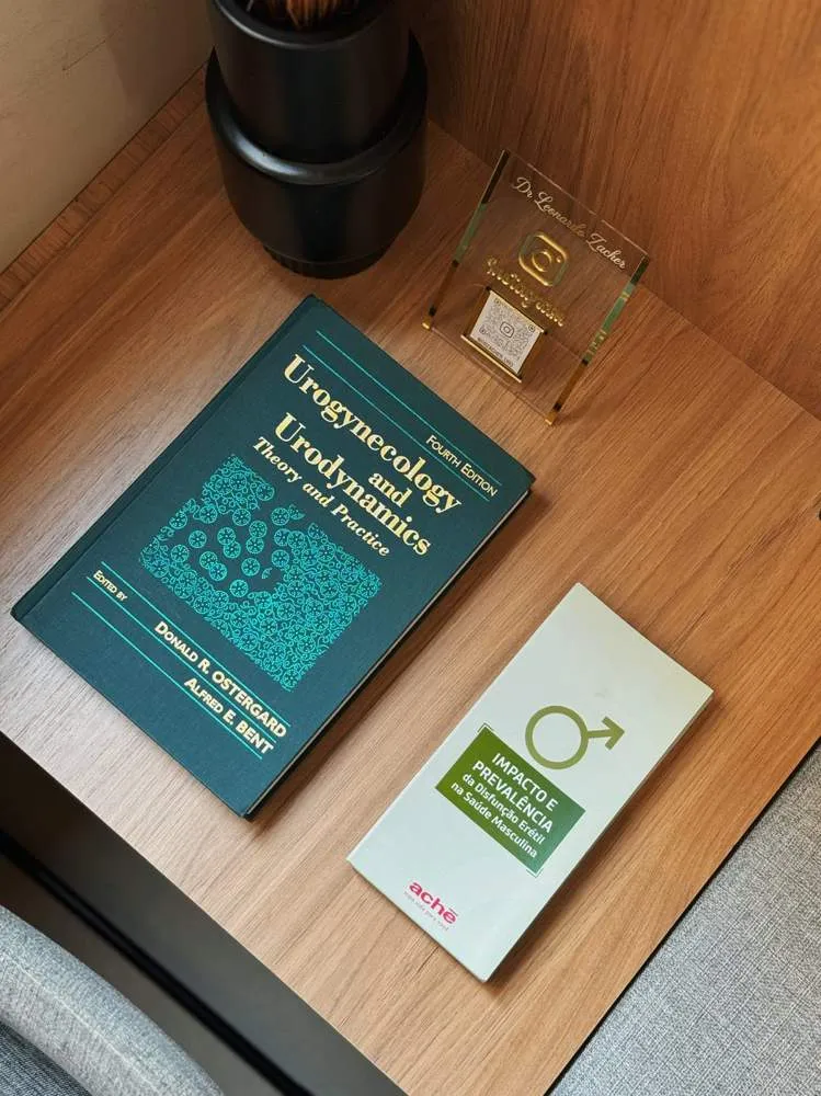 Livro técnico e placa com nome do Dr. Leonardo Zacher no consultório