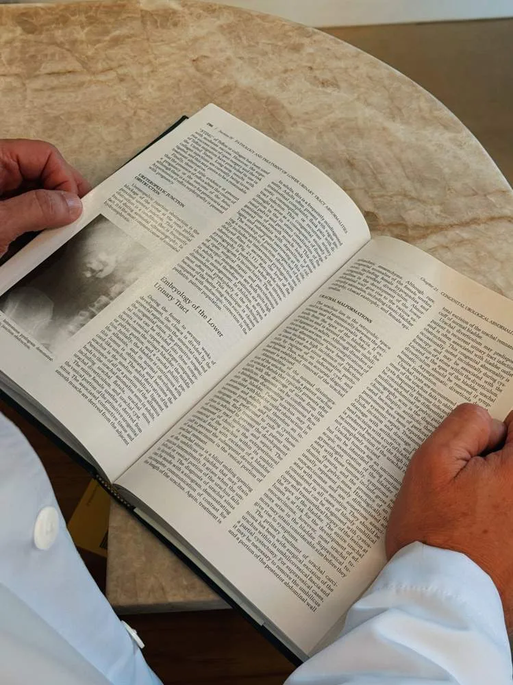 Dr. Leonardo Zacher lendo livro técnico no consultório