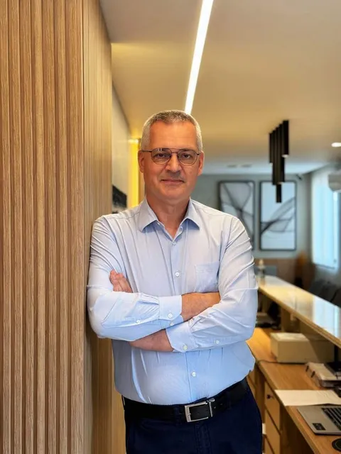 Dr. Leonardo Zacher em pé na recepção da Clínica Menezes & Zacher